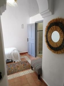 a room with a mirror on the wall and a bed at RIAD MAROSKO in Essaouira