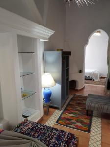 a living room with a blue lamp and a rug at RIAD MAROSKO in Essaouira