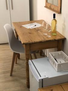 a wooden table with two glasses and a bottle of wine at Le Quattro Porte in Marsala