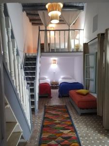 a room with two beds and a staircase at RIAD MAROSKO in Essaouira