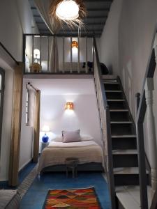 a bedroom with a loft bed and a staircase at RIAD MAROSKO in Essaouira