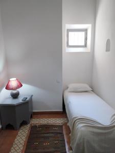 a bedroom with two beds and a table with a lamp at RIAD MAROSKO in Essaouira