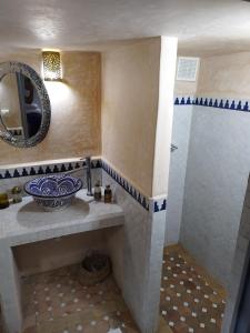 a bathroom with a sink and a mirror at RIAD MAROSKO in Essaouira