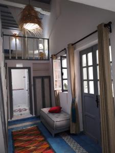 a room with a door and a couch and a window at RIAD MAROSKO in Essaouira
