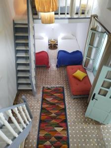 a small room with two beds and a staircase at RIAD MAROSKO in Essaouira