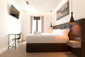 ein Schlafzimmer mit einem großen Bett und einem Stuhl in der Unterkunft Woohoo Rooms Boutique Sol in Madrid