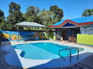 a swimming pool with a playground and a house at Villa Corrales Homestay in Mambajao
