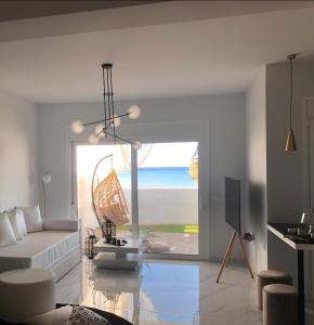 un soggiorno con divano bianco e vista sull'oceano di Longbeachvillas 2 Thesia beachfront villa a Makris Gialos