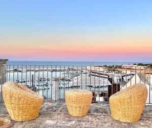 balcone con 3 sedie e vista su un porto turistico. di La Torretta - Marea Collection a Otranto