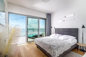 Jurata Residence في يوراتا: غرفة نوم بسرير ونافذة كبيرة