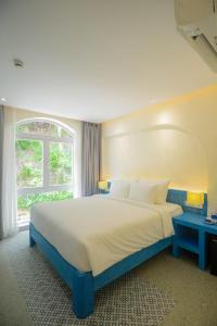 a bedroom with a large bed and a window at SUNTORINI BOUTIQUE HOTEL in Vung Tau