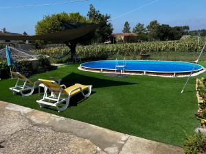 un patio con 2 sillas y una piscina en Casa da Tia en Poutena