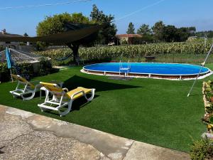 einen Garten mit zwei Stühlen und einem Pool in der Unterkunft Casa da Tia in Poutena