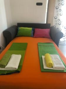 a bed with colorful blankets and pillows on it at Summer & Sunset in Senj