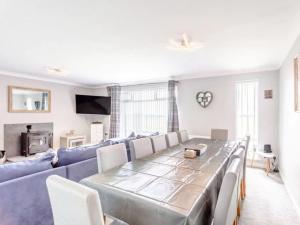 a living room with a long table and a blue couch at Tigh Na Mhor , Hot Tub , Games Room , 5 Bedroom ,Sleeps 13 , Large Villa in Cruden Bay