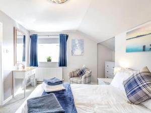 - une chambre blanche avec des rideaux bleus et un lit dans l'établissement Tigh Na Mhor , Hot Tub , Games Room , 5 Bedroom ,Sleeps 13 , Large Villa, à Cruden Bay