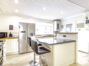 a kitchen with a counter and a refrigerator at Tigh Na Mhor , Hot Tub , Games Room , 5 Bedroom ,Sleeps 13 , Large Villa in Cruden Bay