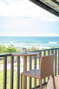 una mesa y una silla en un balcón con vistas al océano en The Palms Resort & Bar, en San Narciso