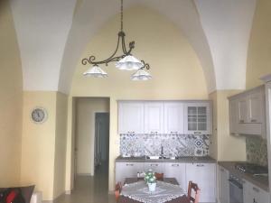 cocina con mesa y lámpara de araña en Albergo Diffuso Cortellenica, en Ugento