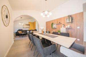 a dining room and living room with a long table and chairs at Sunset Garden apartment with private pool in Vrsi