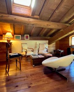 sala de estar con techos de madera, sofá y sillas en Chalet Altus, en Sainte-Foy-Tarentaise