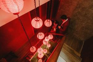 a man and a woman standing in a room with lanterns at Caiyong in Khlong San