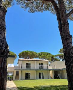 una casa con degli alberi di fronte di Tennis Rocchette Resort a Castiglione della Pescaia