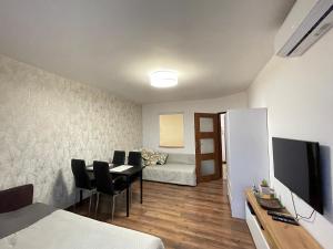 ワルシャワにあるZielna city centerのベッド、テーブル、椅子が備わる小さな客室です。