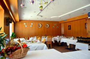 a dining room with white tables and chairs at Albergo Trentino in Moena