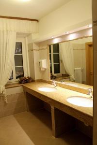a bathroom with two sinks and a large mirror at Albergo Trentino in Moena