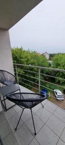 a black chair sitting on a balcony with a fence at Apartament Szczytno - Centrum in Szczytno