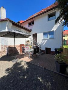 un patio con una mesa y una sombrilla en Ferienhaus Schmalkalden, en Schmalkalden