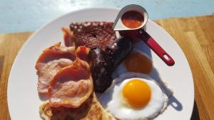 a plate of breakfast food with an egg and bacon at Ronachan in Clachan