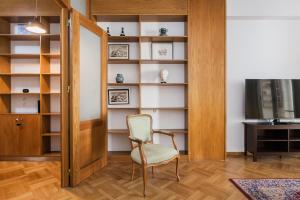 a room with a chair and a book shelf at Neat Kolonaki apartment, Athens city centre - NV8 in Athens