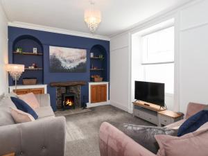 a living room with a fireplace and a tv at Aryelle House in Kendal