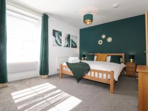 a bedroom with a bed and a green wall at Aryelle House in Kendal