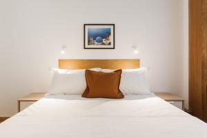 a bedroom with a bed with white sheets and pillows at Neat Kolonaki apartment, Athens city centre - NV8 in Athens