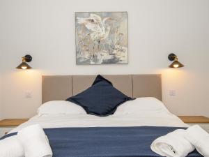 a bedroom with a bed with a painting on the wall at The Forge in Falmouth
