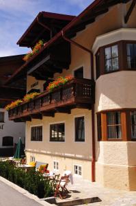 ein Gebäude mit einem Balkon mit Blumen darauf in der Unterkunft Chalet Sonneck in Seefeld in Tirol
