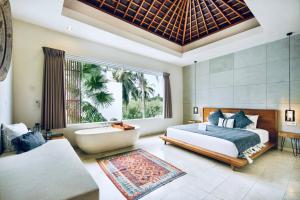 a bedroom with a bed and a tub and a window at Kabila Villas in Kuta Lombok