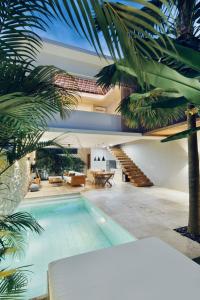 a house with a swimming pool in front of a house at Kabila Villas in Kuta Lombok