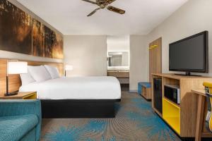 a hotel room with a bed and a flat screen tv at Days Inn by Wyndham Demopolis in Demopolis