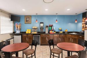 a kitchen with two tables and chairs in it at Days Inn by Wyndham Demopolis in Demopolis