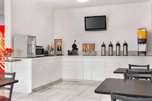 a kitchen with a refrigerator and a tv on the wall at Days Inn by Wyndham Kansas City International Airport in Kansas City