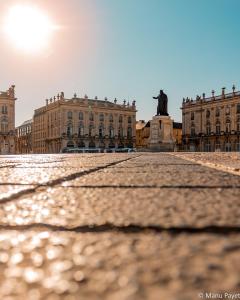 a large stone building with a clock on the side of it at Grand Hotel De La Reine - Place Stanislas in Nancy