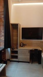 a room with a desk with a flat screen tv at Aparthotel Łódź 55 Piotrkowska in Łódź