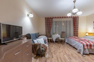 a bedroom with a bed and a flat screen tv at Willa Borowianka in Zakopane