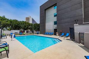 a swimming pool with chairs and a building at La Quinta by Wyndham Houston Southwest in Houston