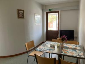 a dining room with a table and chairs and a television at Gracia's Kitchen & Inn in Valtimo