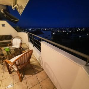 a balcony with chairs and a table on a roof at piu verde1 in Nea Makri